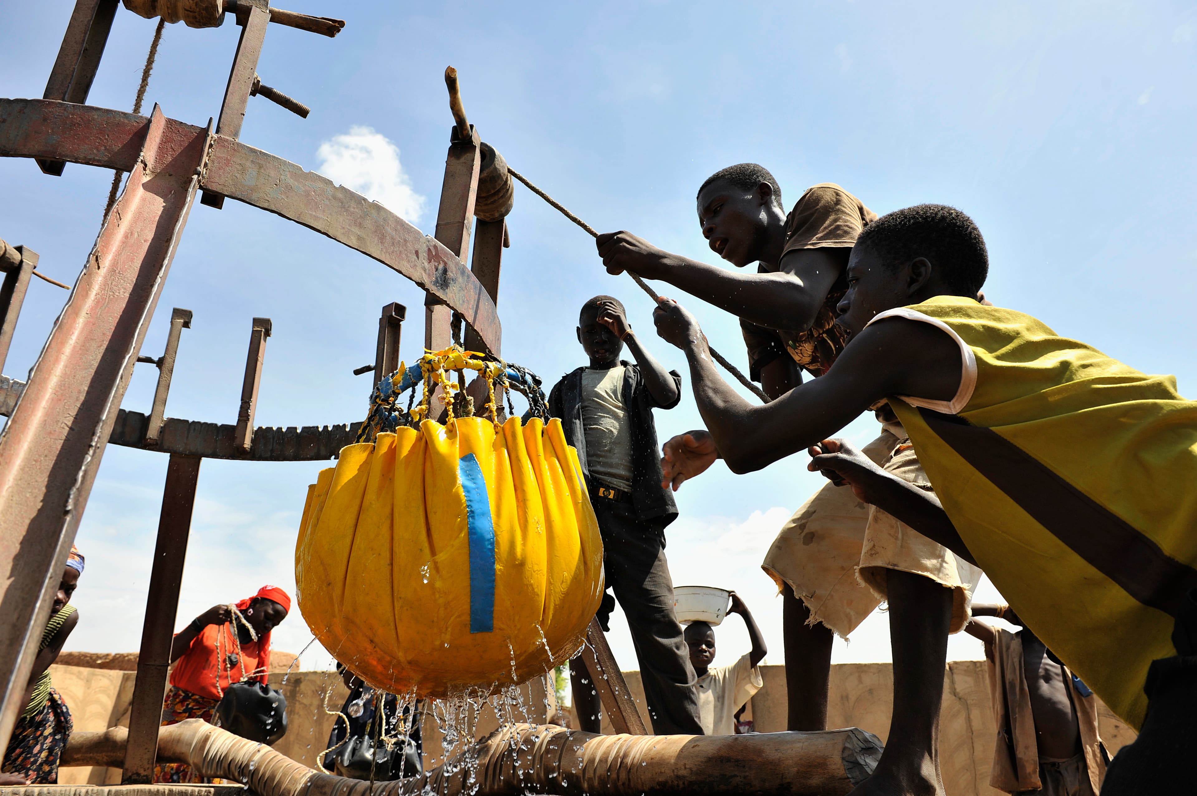 Barn hämtar vatten i en gammal brunn