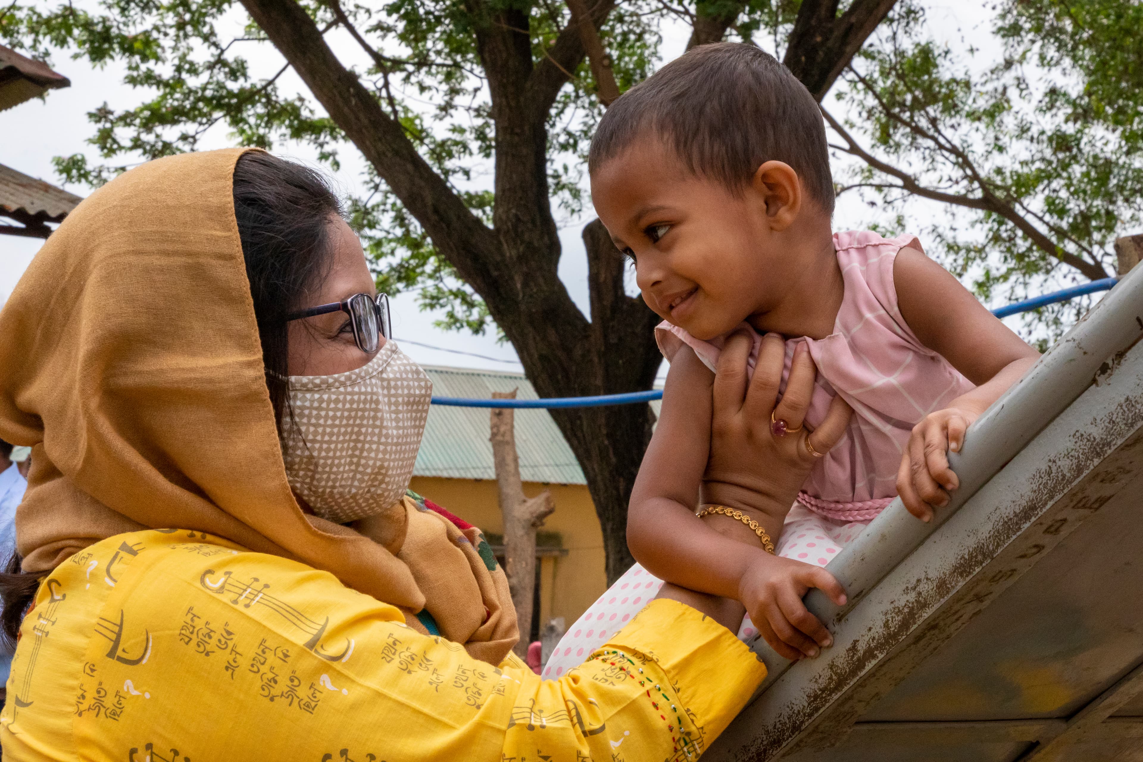 Kvinna leker med barn på skola i Bangladesh