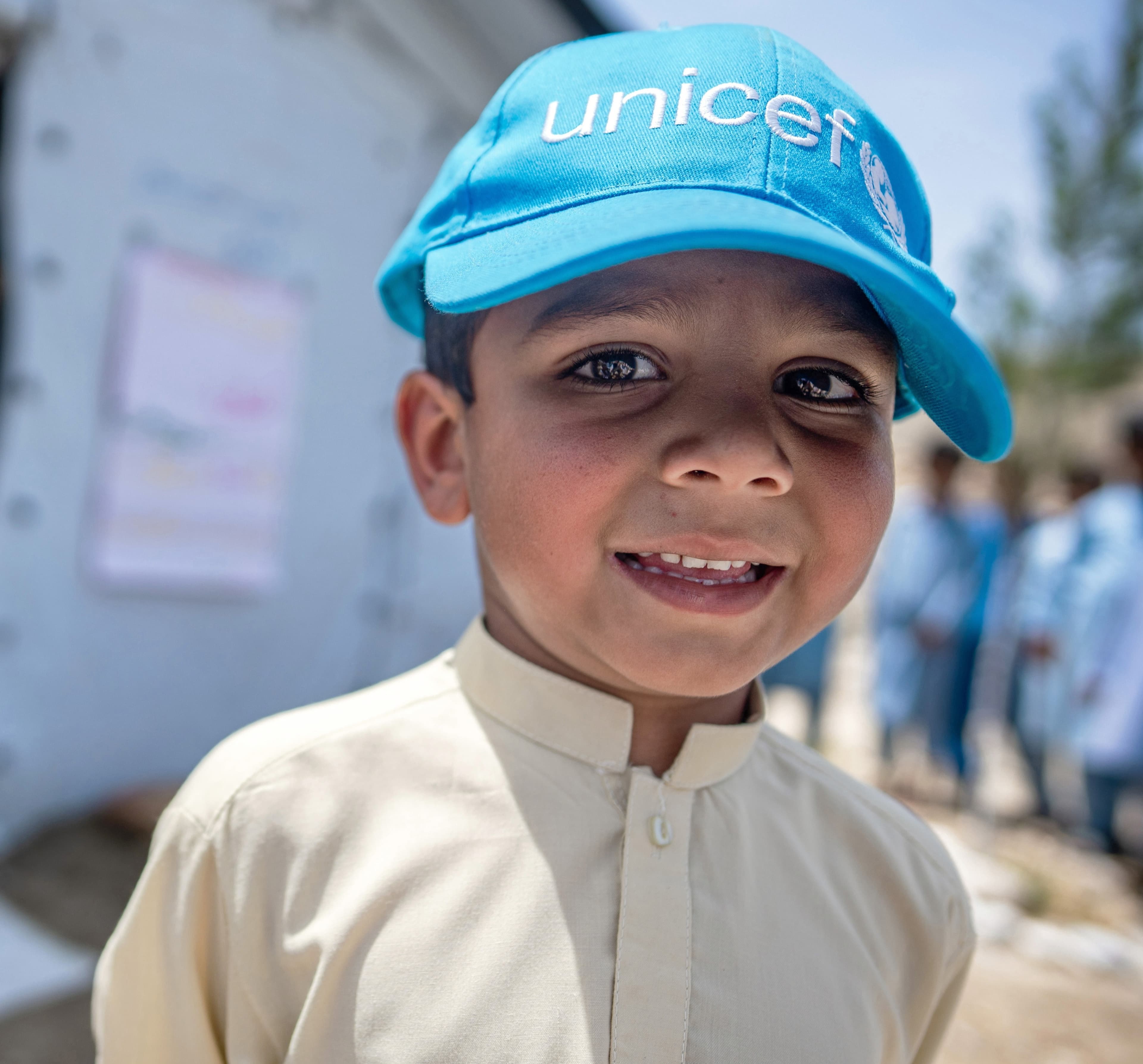 Elev utanför tält - med UNICEF-keps - Afghanistan 2024 - cropped