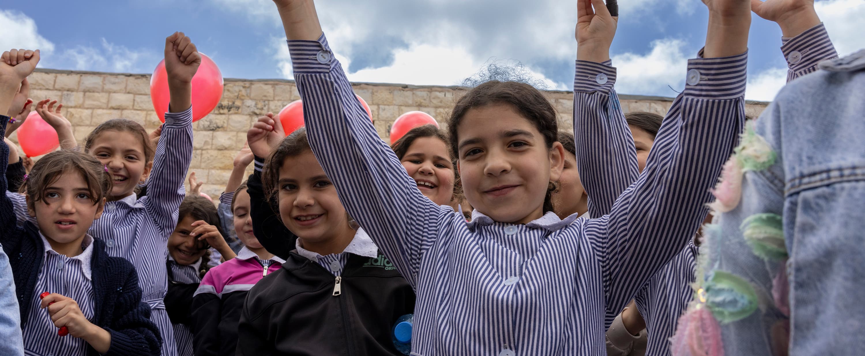 Glada barn utanför skola - Palestina 2025 - desktop