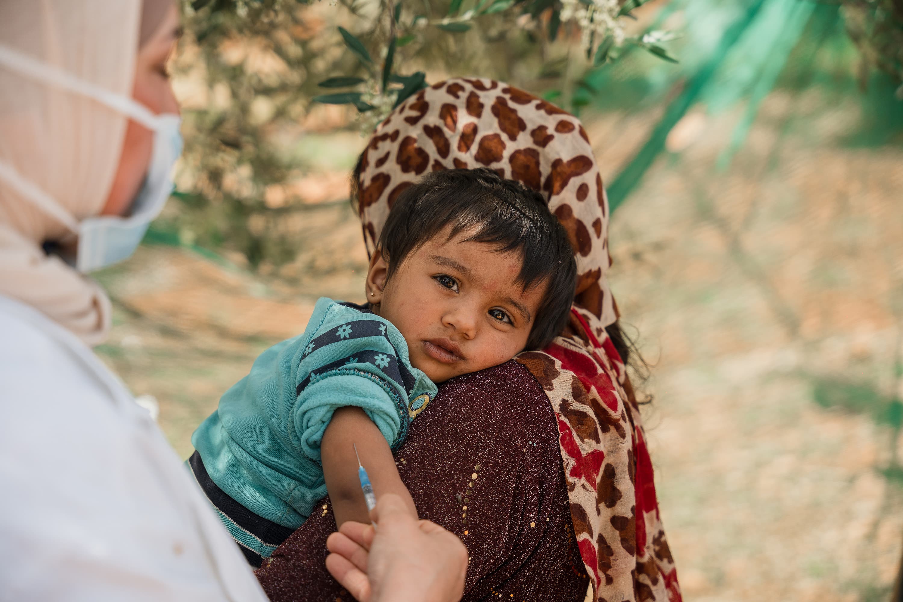Barn vaccineras i mammas famn - vaccin i bild - Jordanien 2024